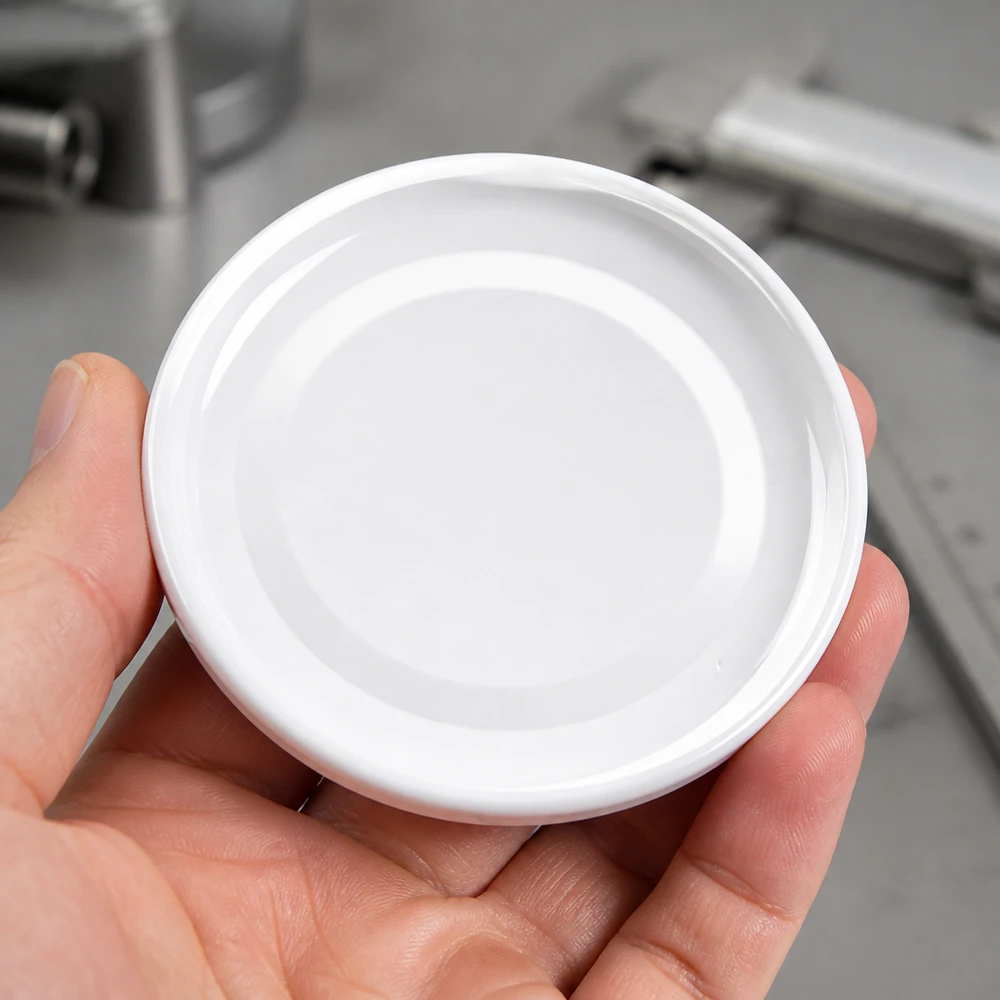 43mm BasicSeal Twist-Off Deckel TO43 weiss aus Metall in der Hand eines Gewerbetreibenden Pacadura
