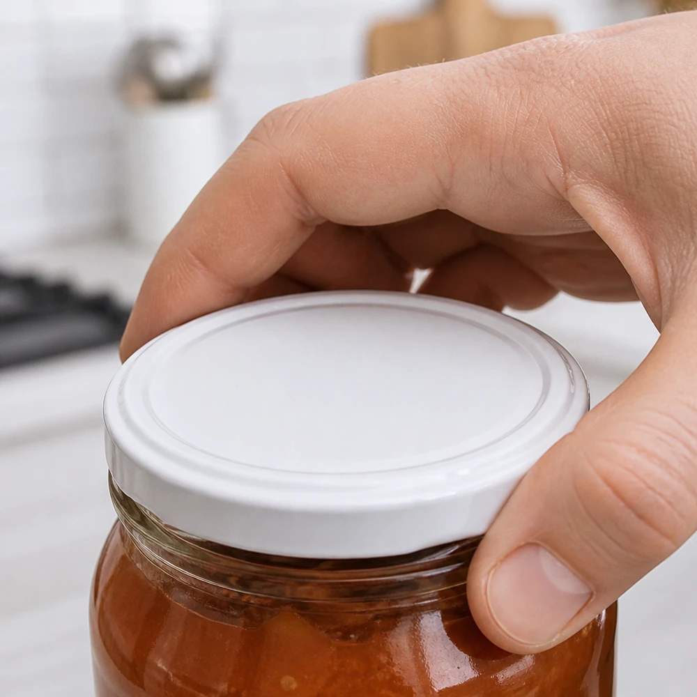 UNiTWIST TO63 weißer BioSeal BPA-NI Twist-Off-Deckel unitemp wird auf Einmachglas mit Marmelade aufgesetzt